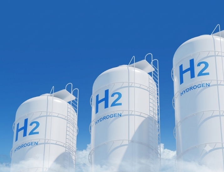 Etanchéité hydrogène - Production d’énergie avec réservoir à gaz à hydrogène au premier plan suivi de panneaux solaires et éoliennes au second plan
